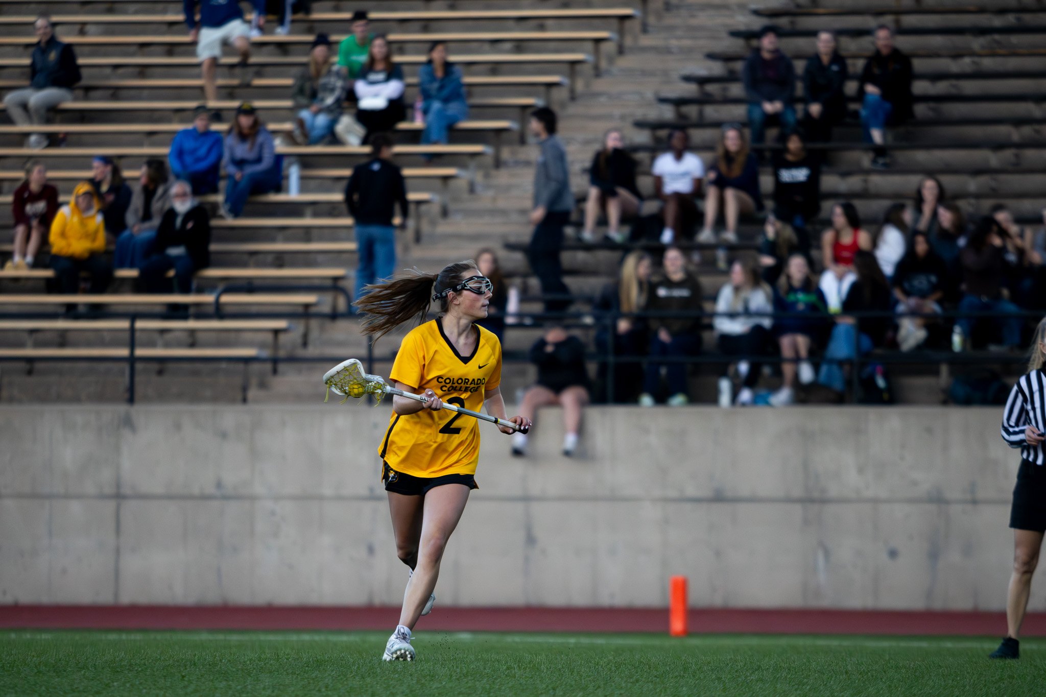 CC women's lacrosse player in full sprint