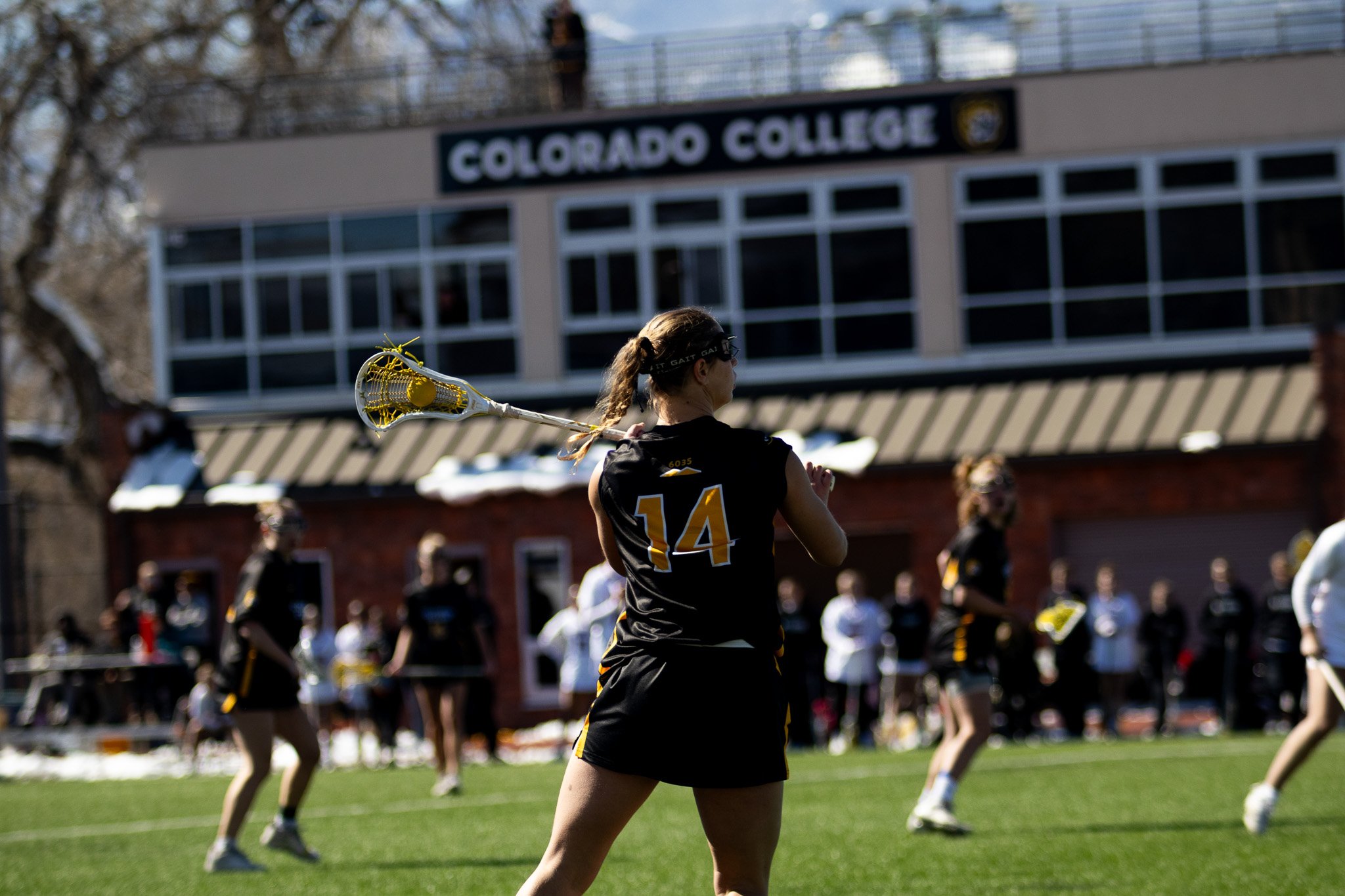CC women's lacrosse player driving past opponent