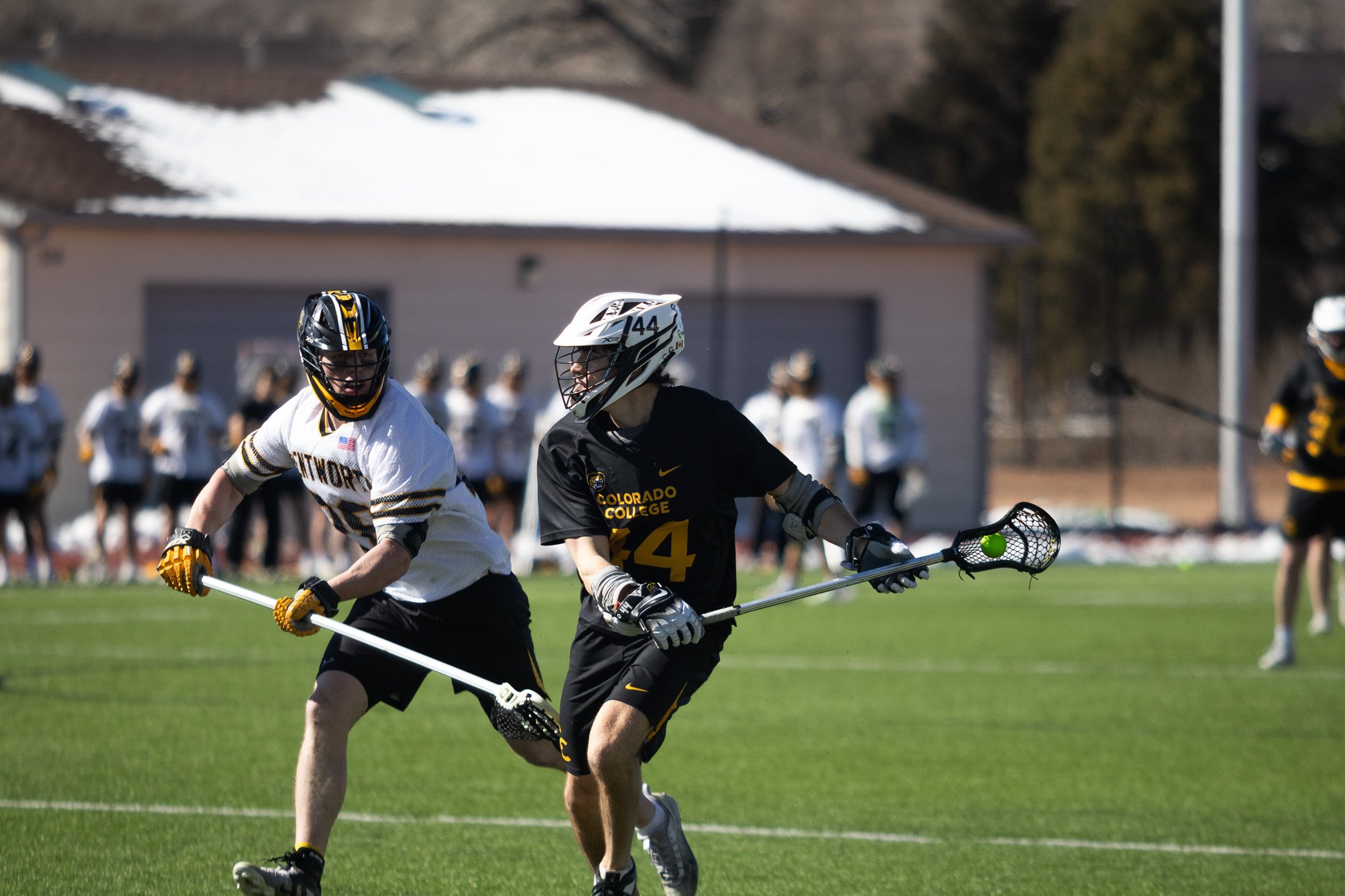CC men's lacrosse player with stick raised